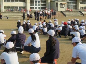 校庭で健康委員会の児童たちが終わりの言葉を話す様子