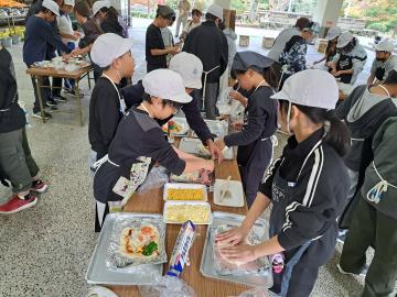 ピザうち体験　トッピングは何にしようかなと児童が具を選ぶ様子