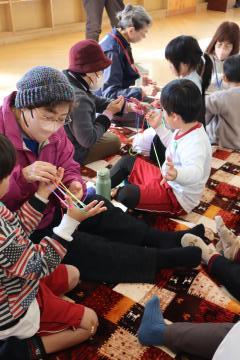 生涯クラブの方から児童があやとりを教わっています