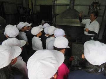 建物内で原料である玉鋼を見る4年生の様子