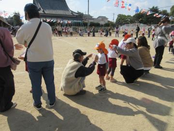 運動場で親から子供にメダルを授与しています。