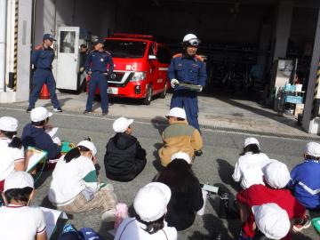 消防署前で職員の始めの挨拶を聴く児童たちの様子