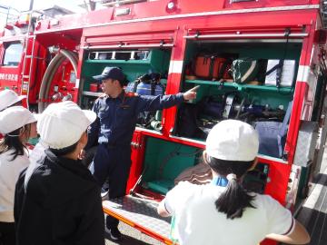 職員から消防車について説明を受ける児童たちの様子