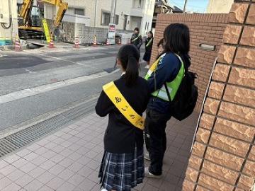あいさつ運動をする小学校の先生と中学生