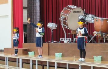 小学校の大舞台でミュージックベルを演奏する子ども達
