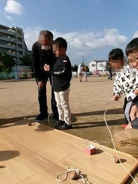 高年者クラブの方にコマ回しを教えてもらっている写真