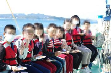 漁業体験をするため船に乗っている児童の様子
