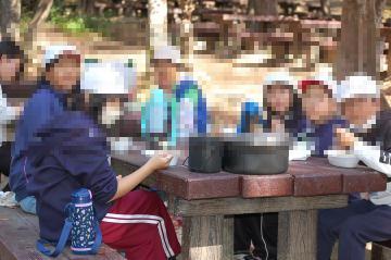 協力してつくったカレーライスをほおばる児童の様子