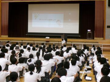 体育館内で講師の方が講演しています。