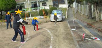 消火訓練をする園児と教師