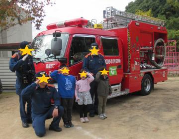 消防車と消防士さんと記念撮影をする園児