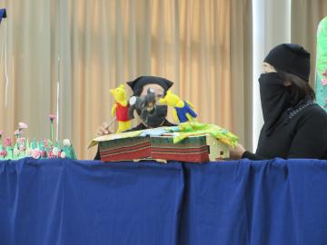 地域の人が黒子になって人形劇をするようす