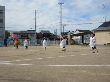 運動場で4歳児がオバケのダンスをする