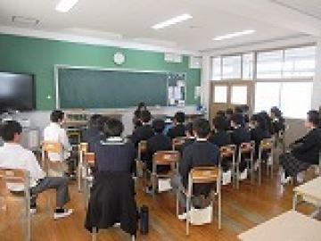 教室で半円の隊形でお話に聞き入る生徒たちの様子