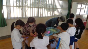 1年生の児童がおりがみを教えてもらっている様子