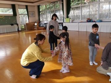 音楽の先生と幼児が握手をする様子