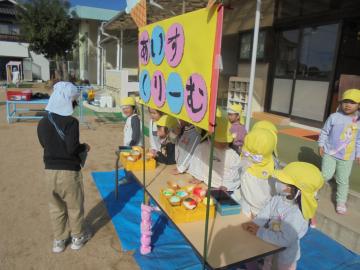 園庭で3歳児がアイスクリームやさんごっこをしている様子