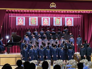 全校生徒が体育館のひな壇に立って合唱をする様子