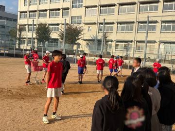 校庭で小学生が部活動を見学する様子