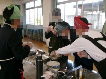 調理室で、生徒が団子の生地を丸めています。