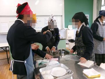 調理室で、生徒がボウルやお皿を洗っています。