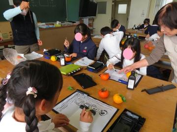 柿の描き方のアドバイスを受ける3年生