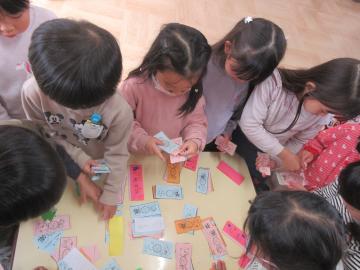 お店屋んごっこのお金を数える幼児