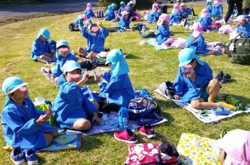 園内の芝生広場でお弁当を食べている園児たちの様子