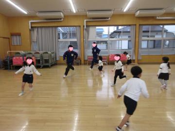 体育館で園児と中学生が鬼ごっこをしている様子