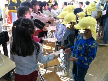 5歳児が財布をつくって4歳児に渡しているところ