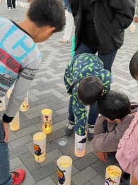 自分の描いた灯籠を見つけて覗き込んでいる児童