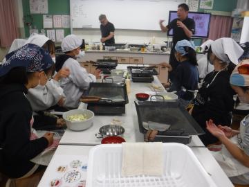 室内で焼き方を教わる児童たちの様子