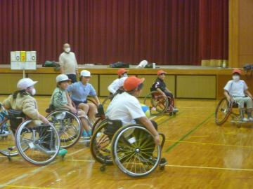 4年生が体育館で車いすバスケットの試合をしている