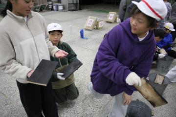 焼き板の炭をとり磨いている様子