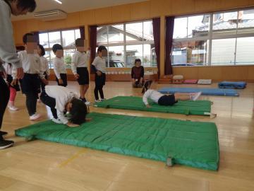 マットの上で一人ずつ前回りをしている