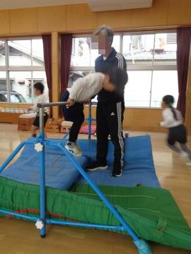 鉄棒で前回りをしている