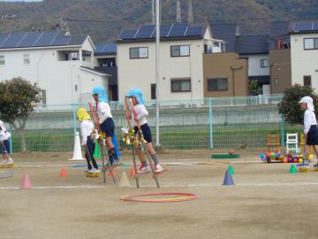 竹馬に乗って障害物を避けたり、トラックを一周したりしている