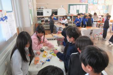 2年生と1年生がお店のテーブルの上でゲームをしている様子