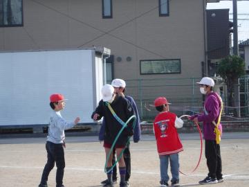 児童がフラフープをくぐる輪くぐりをしている様子