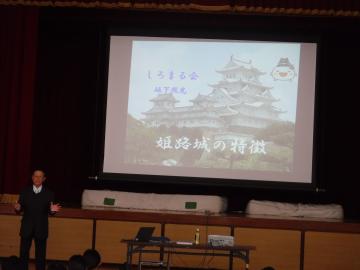 講師が姫路城の画像をスクリーンに映して説明をするようす
