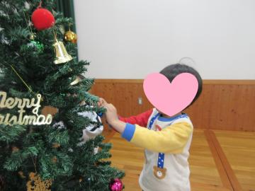 室内でツリーの飾り付けをしている園児の様子