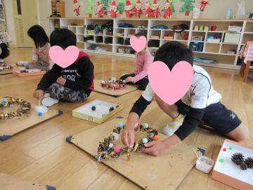 室内でリースを作っている園児たちの様子