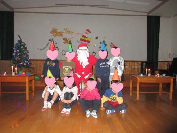 室内でのサンタクロースと園児たちの集合写真
