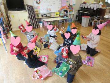 室内でプレゼントをもらって喜んでいる園児たちの様子