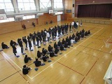 体育館で、クラスごとの代表者が、産休に入られる先生にお礼の言葉を述べる様子