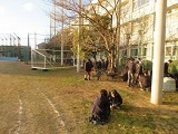 落ち葉を一輪車で運ぶ生徒の様子