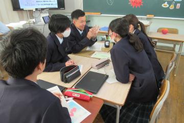 教室の勉強机をくっつけて座り、班で各自のおすすめを紹介している様子