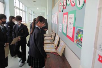 陳列された書籍の前で後期課程の生徒たちがどの本を選ぶか悩んでいる様子