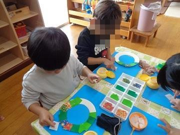 3歳児がクリスマスリースを製作している写真