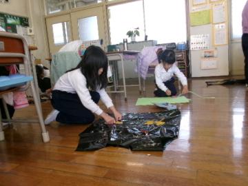 教室内で服を作っている児童たちの様子